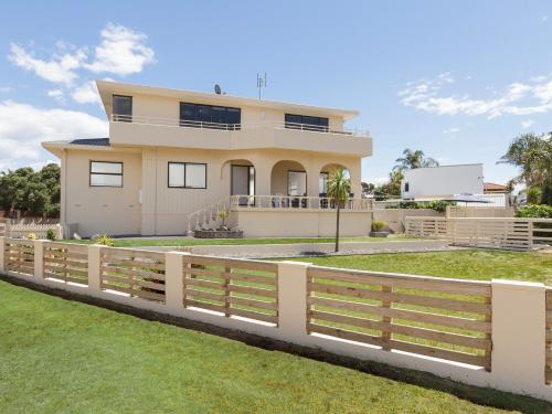 a house with a fence in front of it at Sand Castles - Mount Maunganui Holiday Home in Mount Maunganui