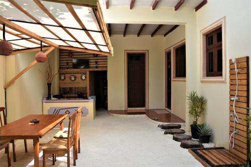a patio with a wooden table and a dining room at Kuri Beach View Inn in Omadhoo