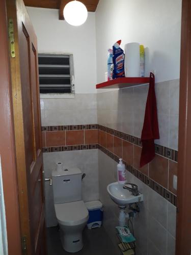 a small bathroom with a toilet and a sink at Villa piscine la Caféière in Lamentin