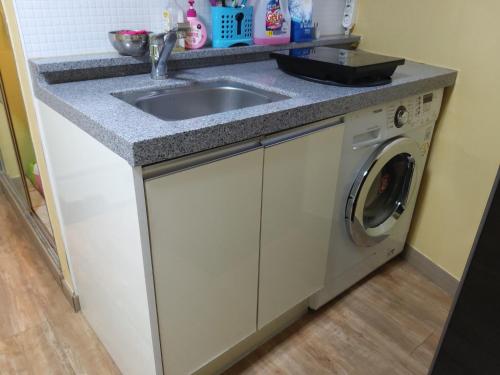 a kitchen with a sink and a washing machine at Cheonggye Haus in Seoul