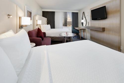 a hotel room with a bed and a living room at Crowne Plaza Dallas Downtown by IHG in Dallas