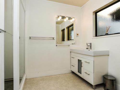 a bathroom with a sink and a mirror at Marine Parade Magic - Napier Holiday Home in Napier