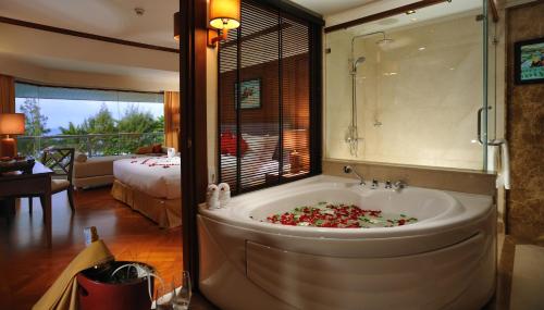 a bathroom with a tub with a bed and a bedroom at Aonang Villa Resort I Beach Front in Ao Nang Beach