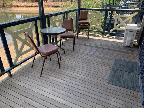 a deck with chairs and a table and a table and chairs at Capital Country Holiday Park in Canberra