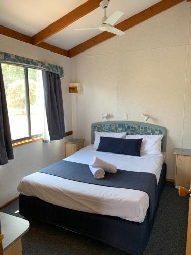 a bedroom with a large bed with blue and white pillows at Capital Country Holiday Park in Canberra