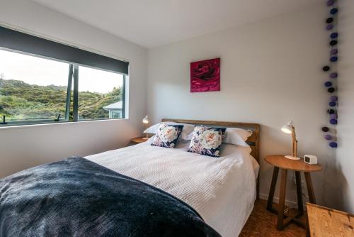 a bedroom with a bed and a large window at Treetop Retreat - Onetangi Holiday Home in Onetangi