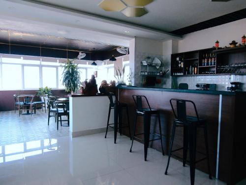 a bar in a restaurant with a group of stools at Hoang Dat Hotel in Dong Hoi