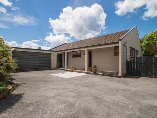 a house with a garage with a driveway at Mokoia Sunrise - Lakefront Ngongotaha Holiday Home in Ngongotaha