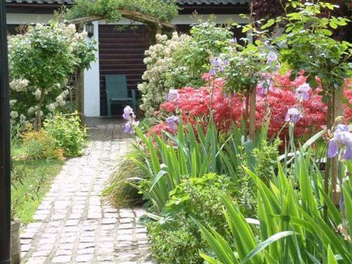 a garden with colorful flowers and a brick walkway at West Lodge Hotel in Aylesbury