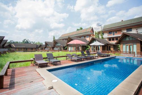 a pool at a resort with chairs and tables at 100 Islands Resort & Spa in Suratthani