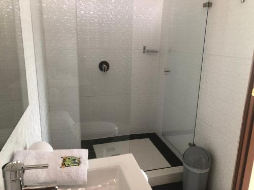 a small bathroom with a sink and a shower at Hotel spa Excalibur in Villeta