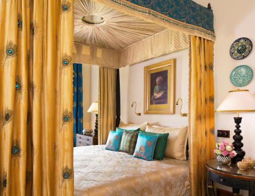 a bedroom with a large wooden canopy bed at Rambagh Palace in Jaipur