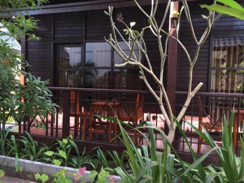 ein Haus mit einem Balkon mit einem Tisch und Stühlen in der Unterkunft Linda Beach Hotel in Nusa Lembongan