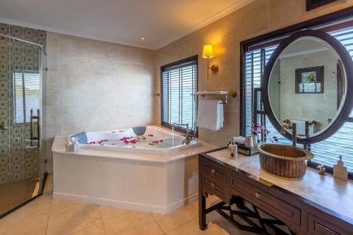 a bathroom with a tub and a large mirror at Heritage Line Violet Cruise - Halong Bay & Lan Ha Bay in Ha Long
