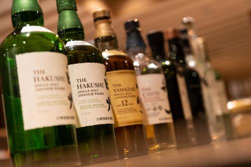 a row of wine bottles sitting on a shelf at PROSTYLE RYOKAN TOKYO ASAKUSA in Tokyo