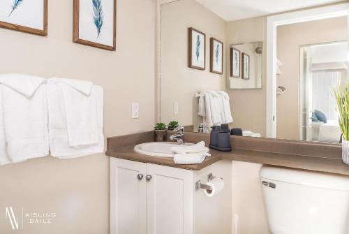 a white bathroom with a sink and a mirror at Rustic Modern 2 Bed 2 Bath with Lakeview Pool and Hot Tub in Invermere