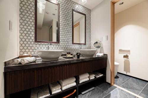 a bathroom with two sinks and a mirror at PROSTYLE RYOKAN TOKYO ASAKUSA in Tokyo