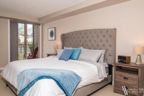 1 dormitorio con 1 cama grande con almohadas azules en Rustic Modern 2 Bed 2 Bath with Lakeview Pool and Hot Tub, en Invermere