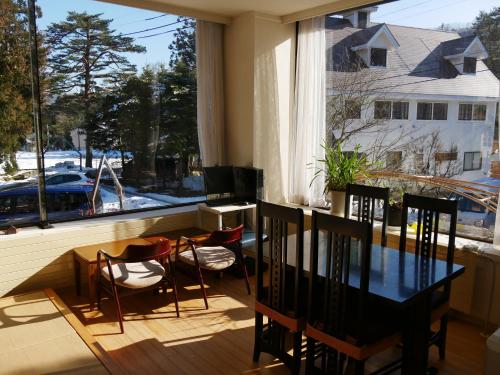 a dining room with a table and chairs and a window at K's House Hakuba Alps - Travelers Hostel in Hakuba