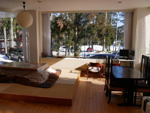 K's House Hakuba Alps - Travelers Hostel في هاكوبا: غرفة معيشة مع سرير وغرفة طعام