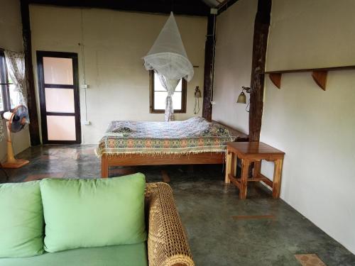 ein Wohnzimmer mit einem Sofa und einem Tisch in der Unterkunft Ing Doi Guest House in Pai