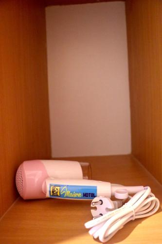 a pink toothbrush and toothbrushes sitting on a table at MAISON HOTEL in Cauayan City