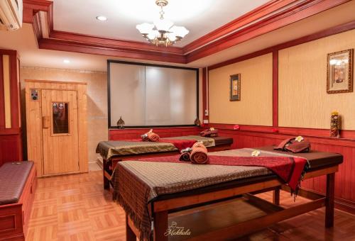 a room with two beds and a projection screen at Tara Lake in Bangkok