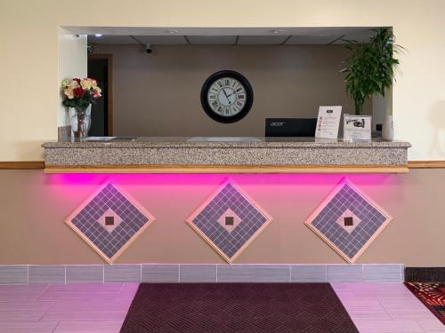 a pink counter with a clock on a wall at Budget Inn & Suites in Nevada