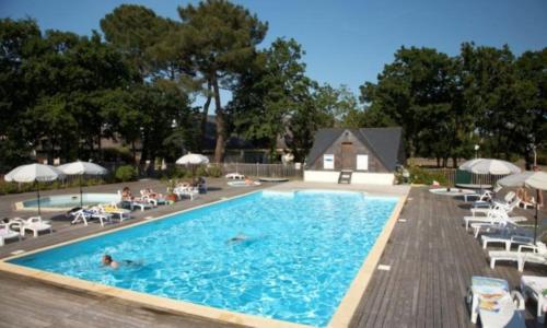 een zwembad waar mensen in zwemmen met stoelen en parasols bij kerloch gwen in Combrit