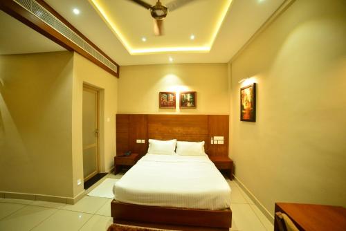 a bedroom with a large bed in a room at Hotel Priya in Kottakkal