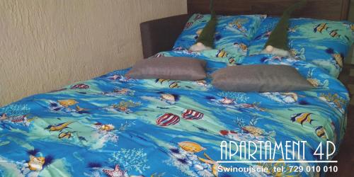 - un lit avec une couette bleue et des oreillers dans l'établissement MIESZKANIE WAKACYJNE 4p, à Świnoujście