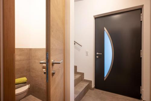 een badkamer met een toilet en een zwarte deur bij Appartement Sophie in Söll