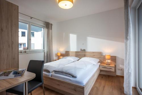 een slaapkamer met een groot bed, een bureau en een bureau bij Appartement Sophie in Söll