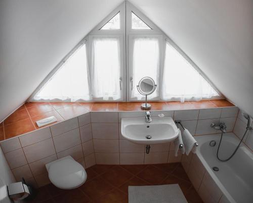 a bathroom with a sink and a toilet and a window at Appartements Ferienwohnungen Alpenblick in Faistenau