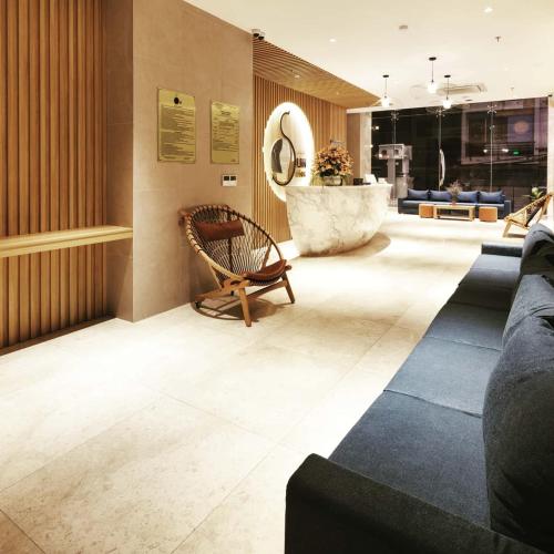 a lobby with a chair and a bench in a building at Sun Kiss Hotel in Nha Trang