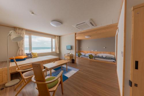 a bedroom with a bed and a desk and a table at Hotel Kifu Club Shiretoko in Shari