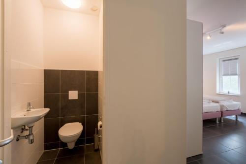 La salle de bains est pourvue de toilettes et d'un lavabo. dans l'établissement Appartement - Kaapduinseweg 13 Dishoek 13H Luxe 6 personen, à Koudekerke