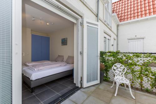 - une chambre avec un lit et une chaise sur un balcon dans l'établissement Appartement - Kaapduinseweg 13 Dishoek 13H Luxe 6 personen, à Koudekerke