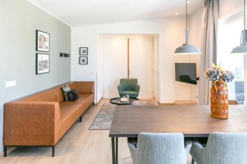 sala de estar con sofá y mesa en 6p Luxe bungalow met serre en 's-Gravenzande