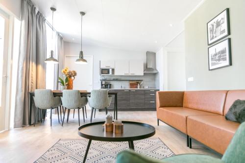 uma sala de estar com um sofá e uma mesa em 8p Luxe bungalow met serre em s-Gravenzande