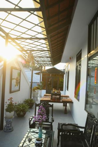 a patio with a table and chairs and flowers at Asean Garden Homestay Hue in Hue