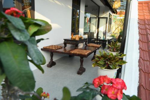 two benches on a porch with plants and flowers at Asean Garden Homestay Hue in Hue
