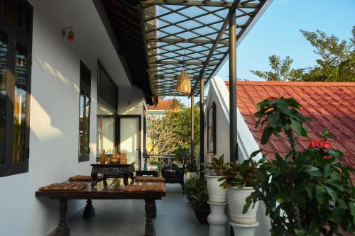 an outdoor patio with a table and potted plants at Asean Garden Homestay Hue in Hue