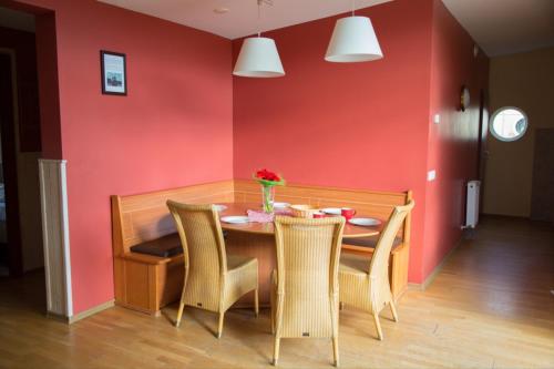 ein Esszimmer mit einer roten Wand sowie einem Tisch und Stühlen in der Unterkunft Bungalow 6 personen in s-Gravenzande