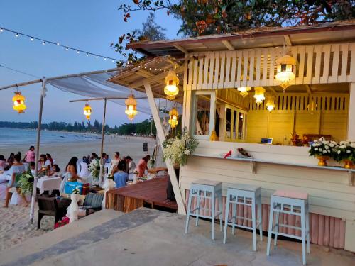 a restaurant on the beach with a crowd of people at Banana Beach Resort in Ko Lanta