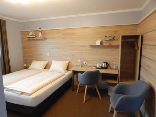 um quarto de hotel com uma cama, uma mesa e cadeiras em Hotel garni Haaster Krug Otte em Großenkneten