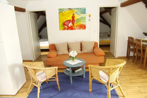 a living room with a couch and chairs and a table at Schwalbennest auf dem Weingut Arthur Melsheimer in Maring-Noviand