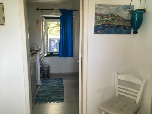 斯佩察島的住宿－Toula's house 2，走廊,门通往带蓝色窗帘的房间