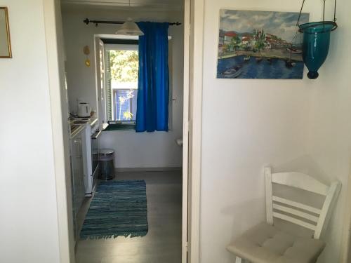 a hallway with a door leading to a room with blue curtains at Toula's house 2 in Spetses