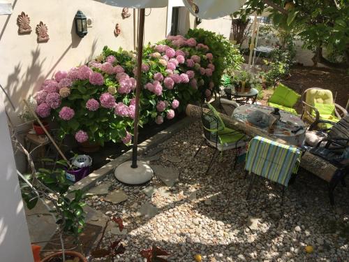 a garden with pink flowers and a table and chairs at Toula's house 2 in Spetses